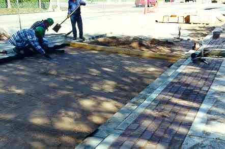 Originalbricks are being re-installed in 2 ft. strip between curb and sidewalk